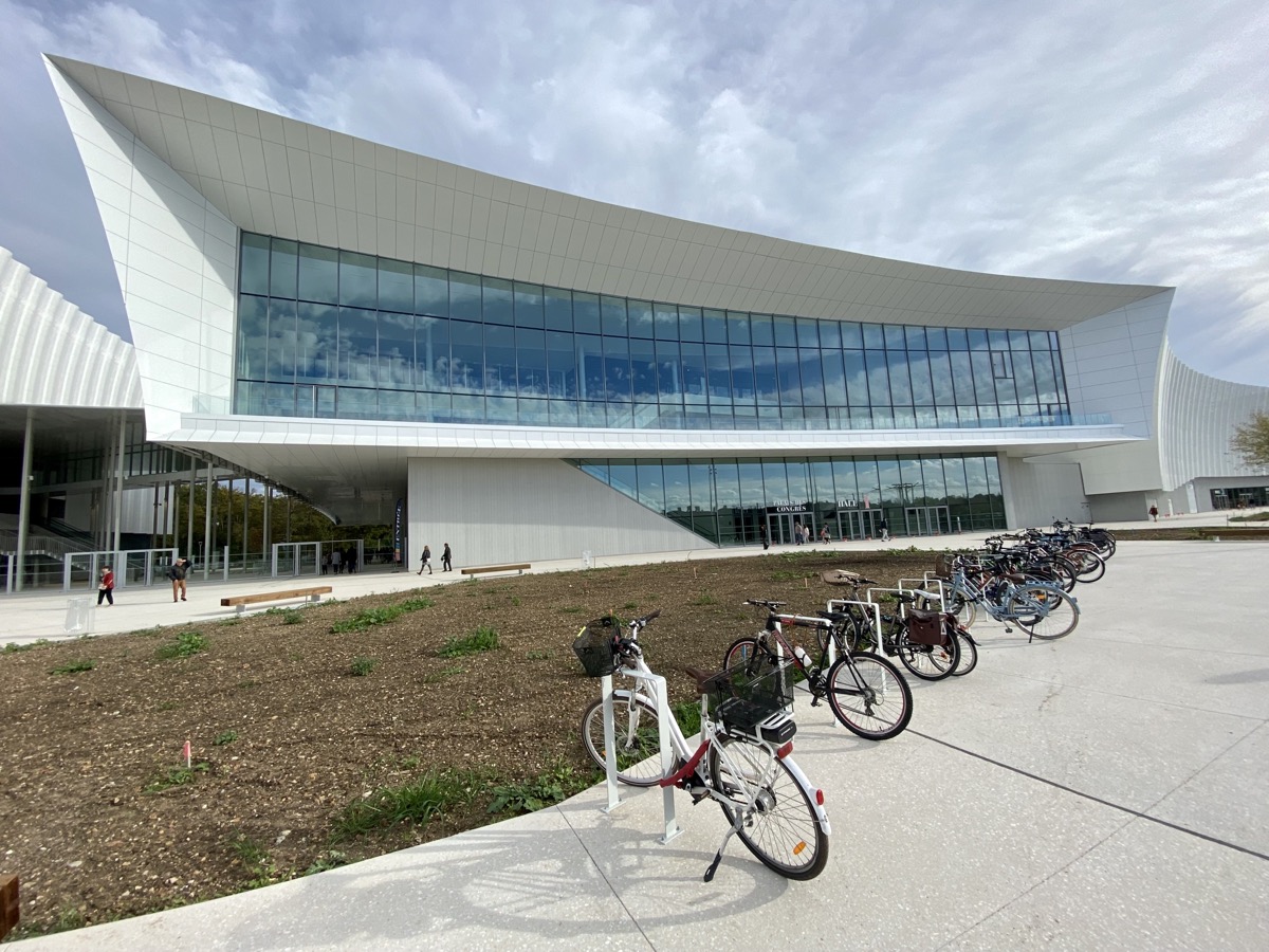 Façade moderne du Palais des Congrès CO’Met à Orléans avec un parking à vélos au premier plan.